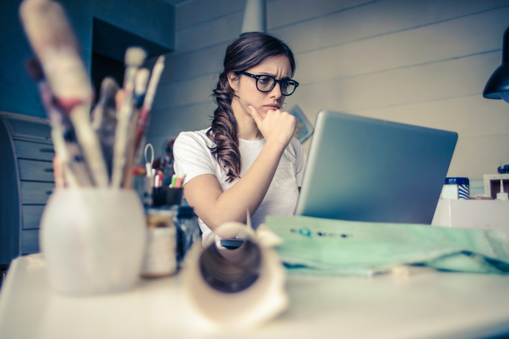 accountant thinking while looking at her laptop