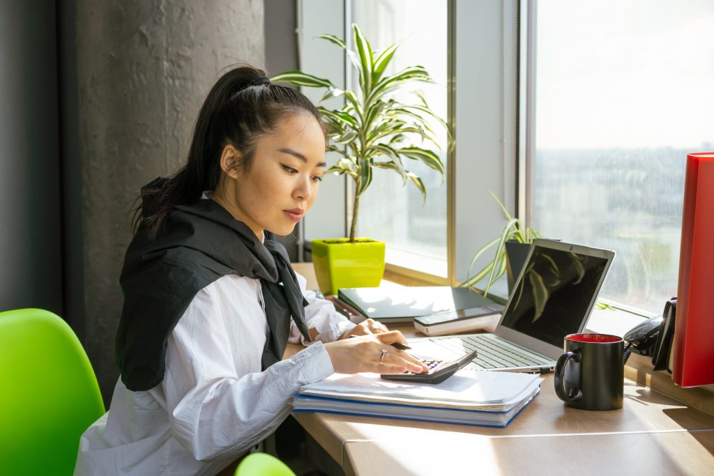 accountant using her calculator white on top of her notebook