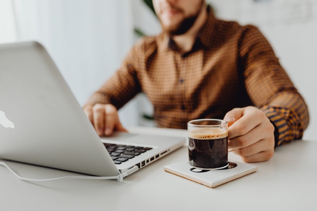 accountant working using a macbook while drinking coffee